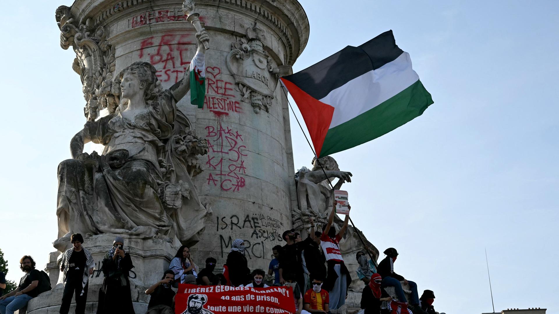 Demonstranten schwenken die palästinensische Flagge auf dem Place de la Republique in Paris. Demonstranten schwenken die palästinensische Flagge auf dem Place de la Republique in Paris.