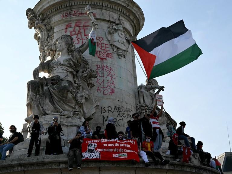 Demonstranten schwenken die palästinensische Flagge auf dem Place de la Republique in Paris.