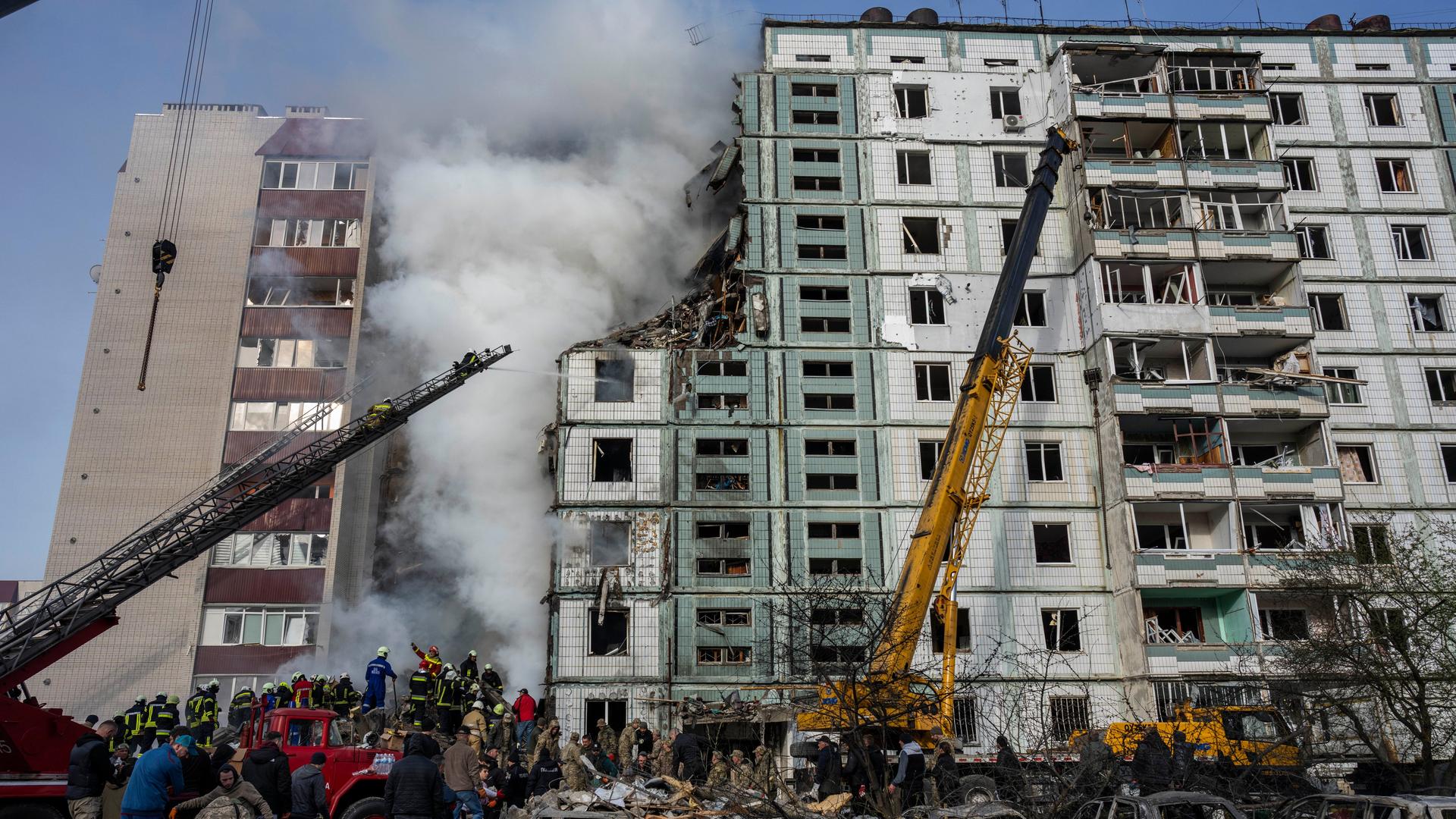 Ukraine, Uman: Feuerwehrleute löschen ein Feuer nach einem russischen Angriff auf ein Wohnhaus