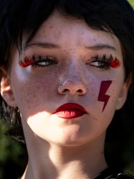 Abtreibungsbefürworter in Polen am 23. Juli 2024 vor dem polnischen Parlament. Eine junge Frau mit Gesichtbemalung. 