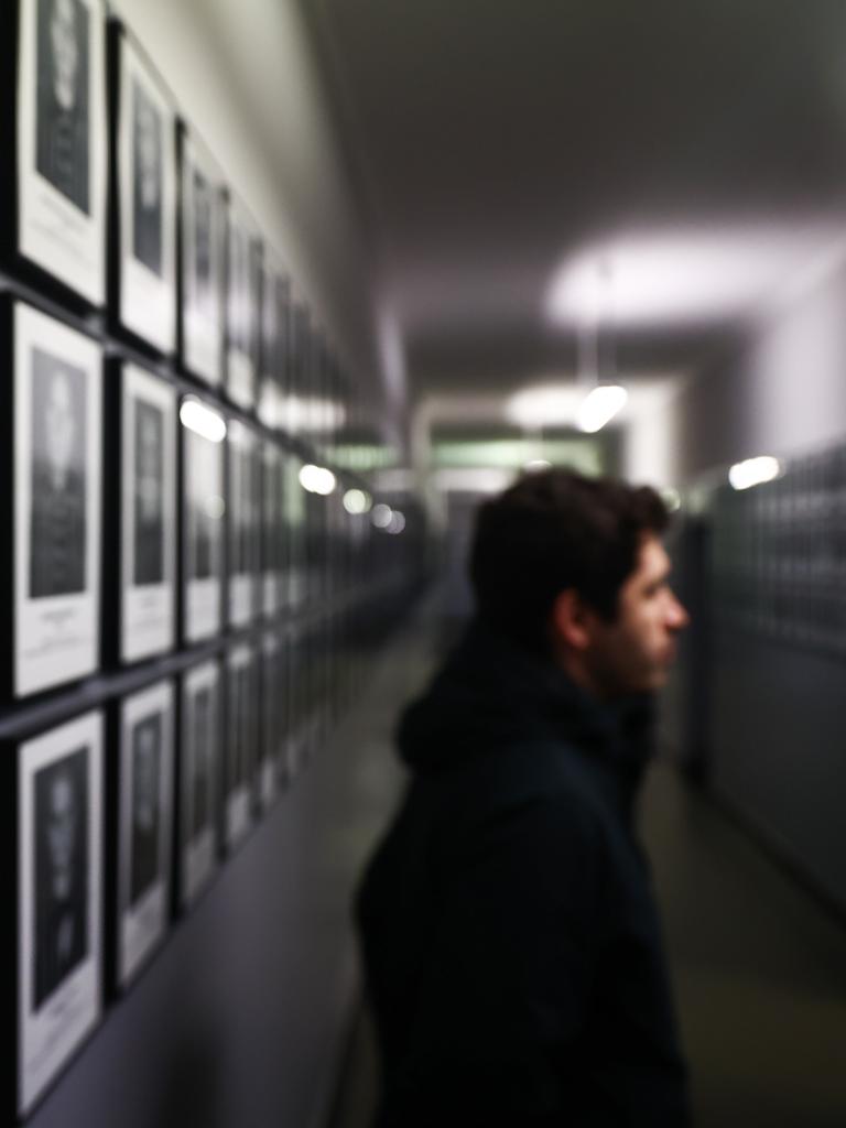 Ein Besucher der Gedenkstätte Auschwitz betrachtet Fotos ehemaliger Häftlinge des Konzentrationslagers Auschwitz 