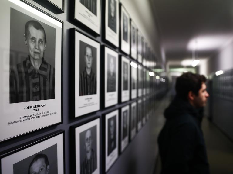 Ein Besucher der Gedenkstätte Auschwitz betrachtet Fotos ehemaliger Häftlinge des Konzentrationslagers Auschwitz 