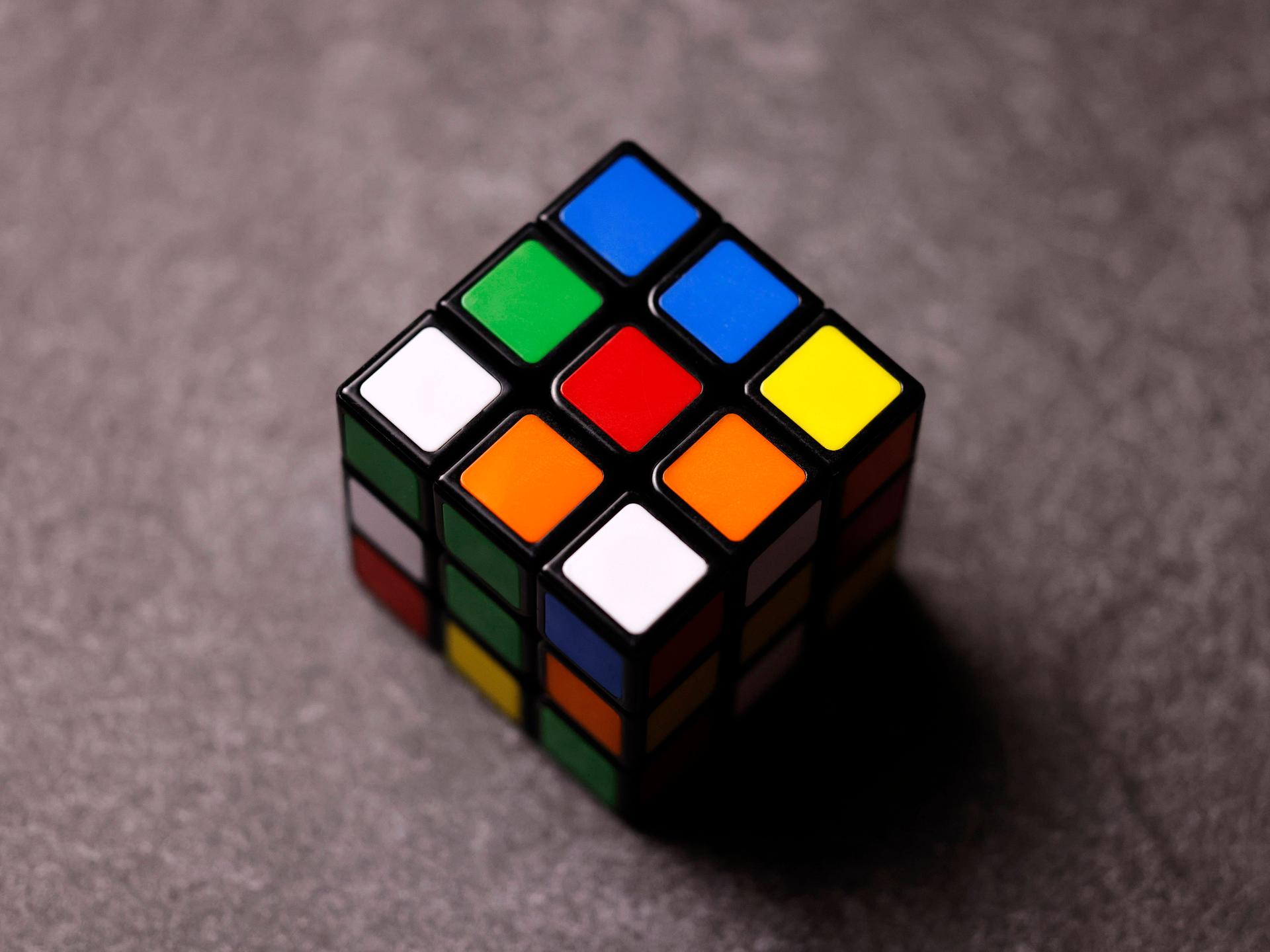 Ein klassischer Zauberwürfel ("Rubik’s Cube") liegt auf einem Tisch.