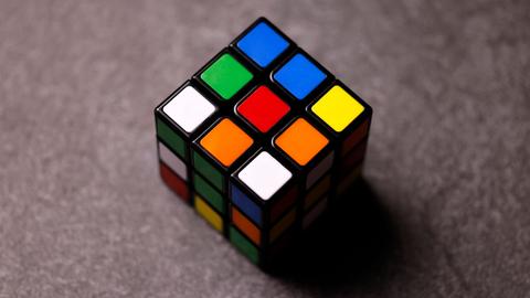 Ein klassischer Zauberwürfel ("Rubik’s Cube") liegt auf einem Tisch.