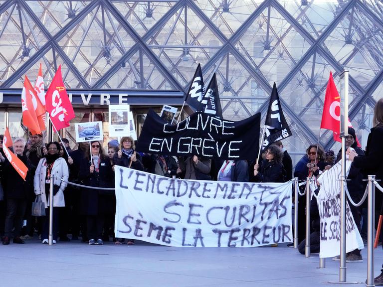 Workers display banners outside the Louvre museum after they voted to strike for the day over working conditions and other complaints, Monday, Dec. 15, 2025 in Paris. (AP Photo/Michel Euler)
