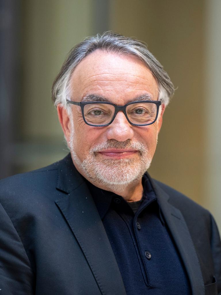 Natan Sznaider im Vorfeld einer Veranstaltung. Er lächelt zurückhaltend, der Hintergrund ist unscharf. Er trägt eine Brille mit dunklem Rand und ein dunkelblaues Sakko. 