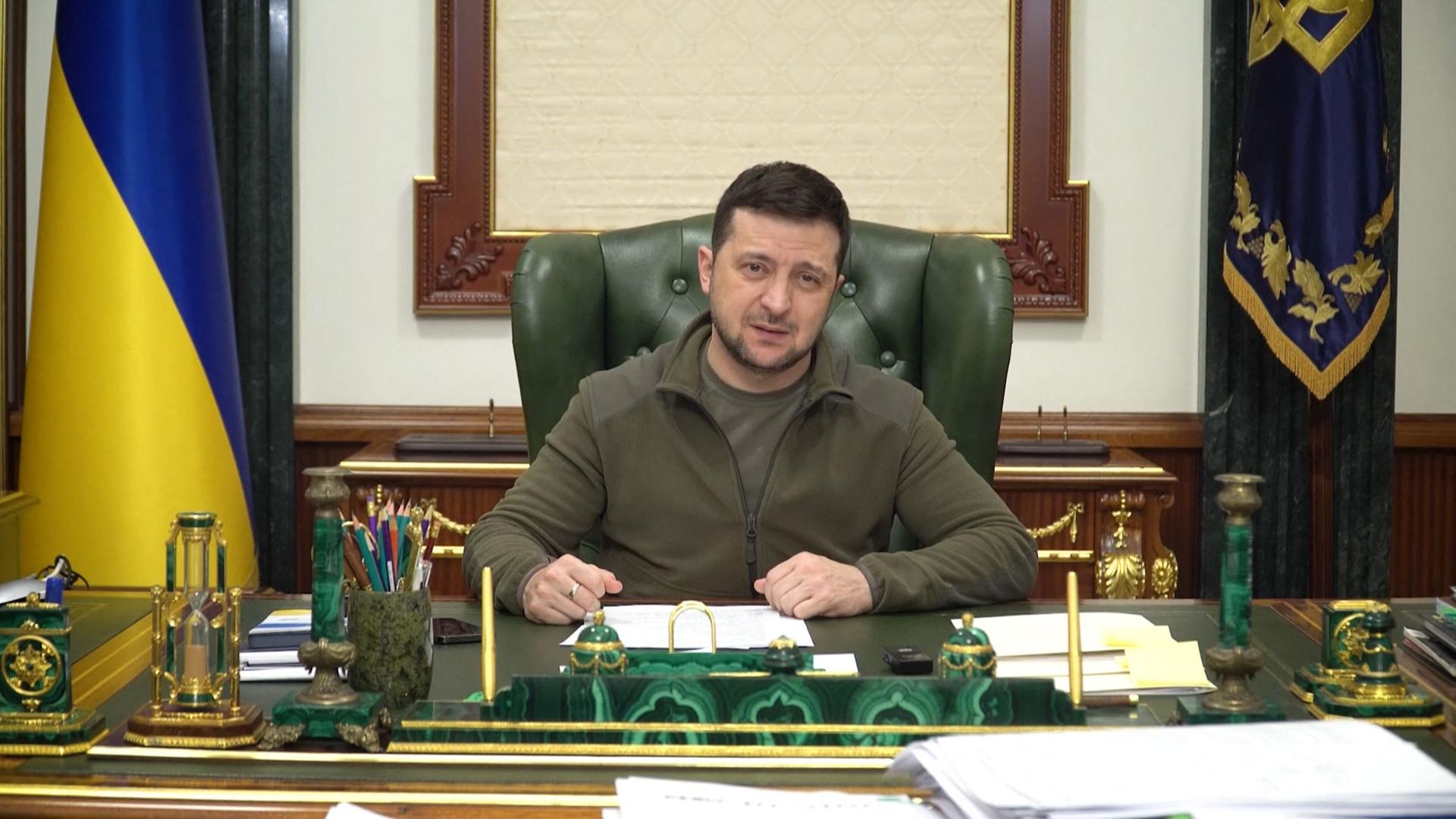 Der ukrainische Präsident Selenskyi sitzt an einem Schreibtisch.