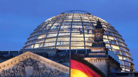 Vor dem Reichstagsgebäude weht eine schwarz-rot-goldene Deutschland-Fahne.