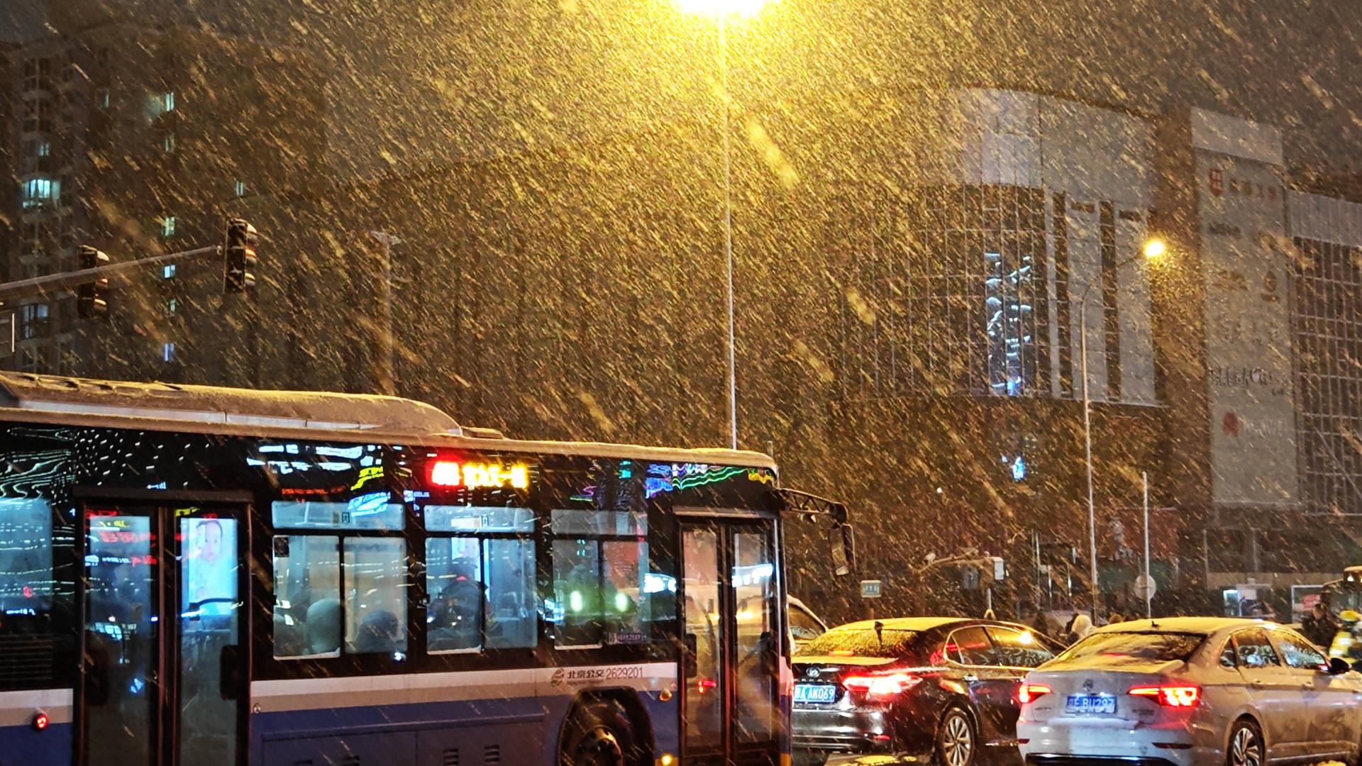 Eine stark befahrende Straße bei starkem Schneefall in Beijing. Eine stark befahrende Straße bei starkem Schneefall in Beijing.