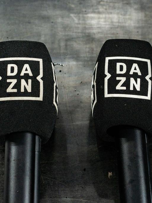 Zwei Mikrofone mit dem DAZN-Logo liegen am Boden und sind zu sehen. 