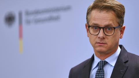 Ein Mann im Anzug, kurze Haare, Brille, schaut in die Kamera
