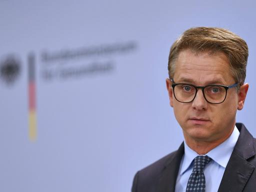 Ein Mann im Anzug, kurze Haare, Brille, schaut in die Kamera