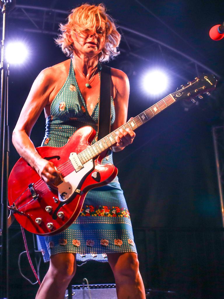 Das Foto zeigt Bernadette La Hengst im engen Kleid und mit breiter roter E-Gitarre in Aktion auf der Bühne. 