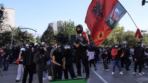 Junge Demonstranten posieren mit der albanischen Nationalflagge und formen mit ihren Händen den Doppeladler – während studentisch geprägter regierungsfeindlicher Proteste in Tirana, Albanien.