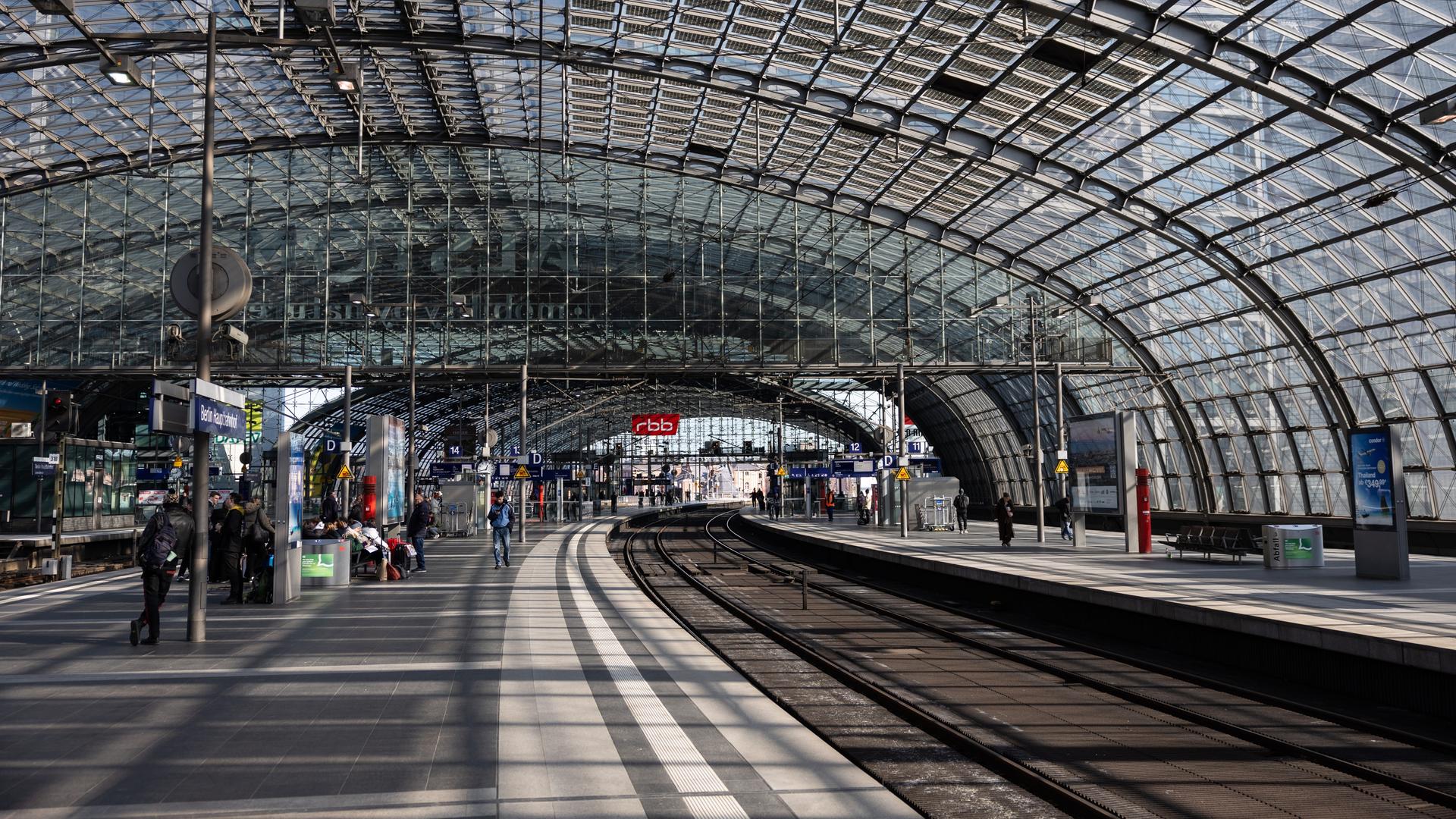 Wenige Menschen stehen an einem Bahnsteig am Berliner Hauptbahnhof. Ein Zug ist nicht zu sehen.