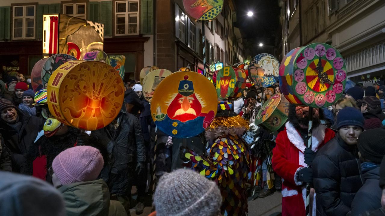 Fasnachtsvereine mit Laternen ziehen durch die Straßen von Basel.