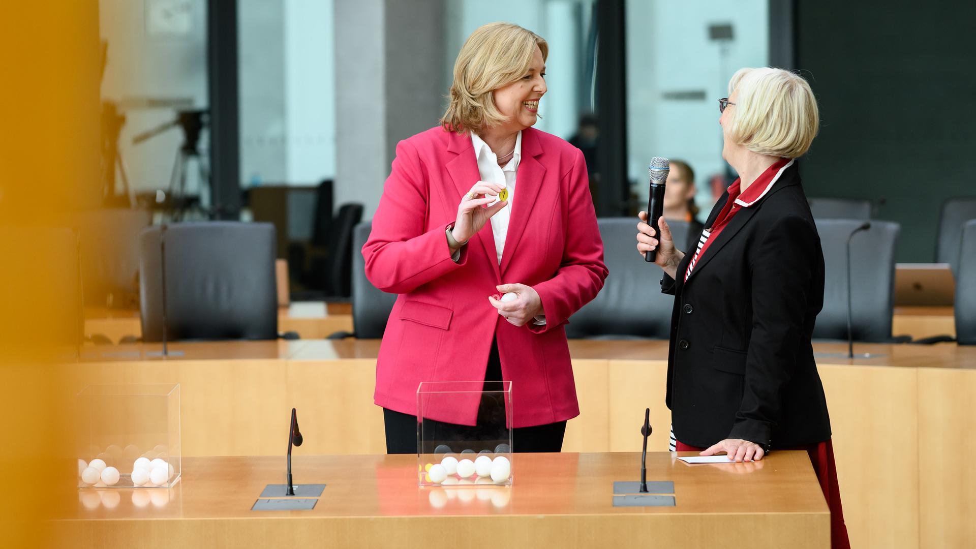 Bundestagspräsidentin Bärbel Bas steht vor einem Gefäß mit weißen Nummern und zieht daraus.