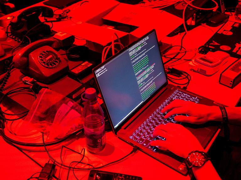 Ein Computer und alte Telefone stehen beim Kongress des Chaos Computer Clubs (CCC) auf einem Tisch. 