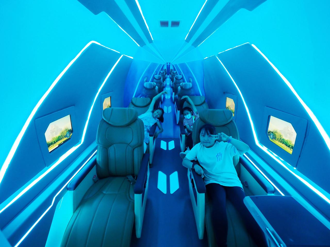 Kinder erleben einen Hochgeschwindigkeitsflug in einem Automodell auf einer Zukunftsmesse in der chinesischen Hauptstadt Peking. 