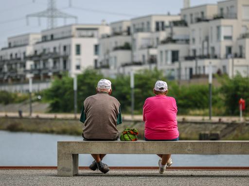 Senioren sitzen auf einer Parkbank am Yachthafen im neuen Stadtquartier von Gelsenkirchen.