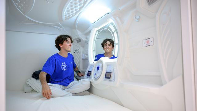 Eine Person sitzt in einem kleinen Raum zum Schlafen.