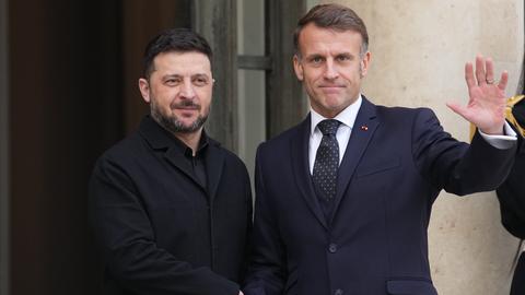 Der französische Präsident Emmanuel Macron (rechts) begrüßt den ukrainischen Präsidenten Wolodymyr Selenskyj vor einem Treffen im Élysée-Palast in Paris. 
