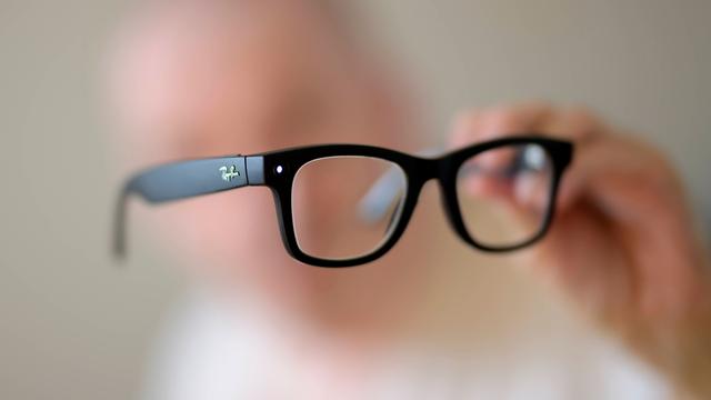 Eine schwarze KI Brille in der Hand eines Menschen