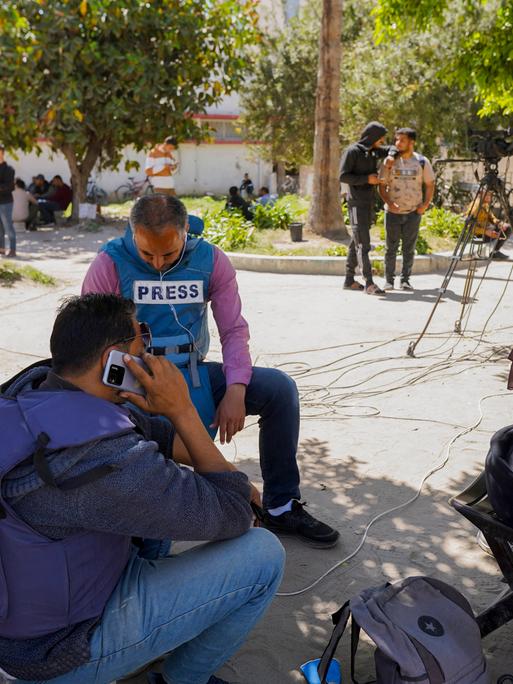 Journalisten sitzen unter einem Baum im Norden Gazas