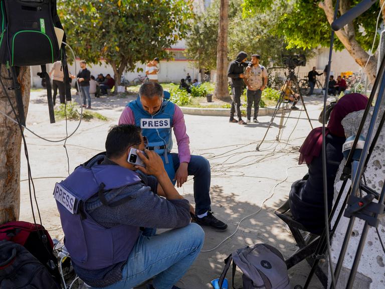 Journalisten sitzen unter einem Baum im Norden Gazas