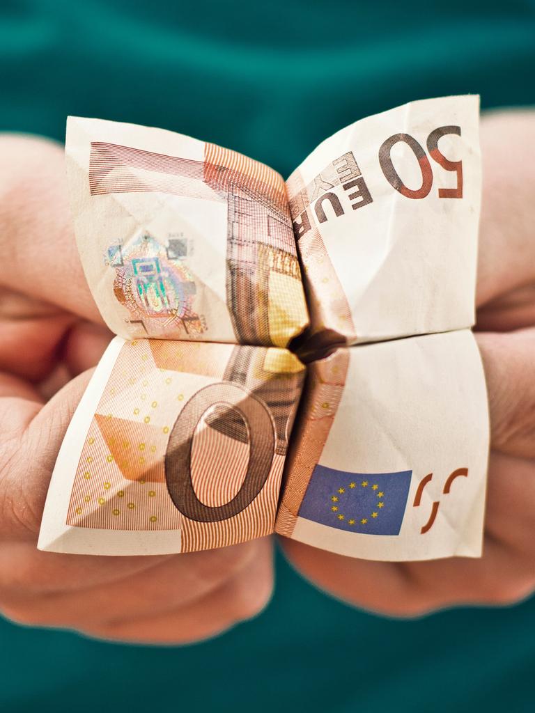 Kinderhände, die einen aus einem 50-Euro-Schein gebastelten Papier-Wahrsager halten.