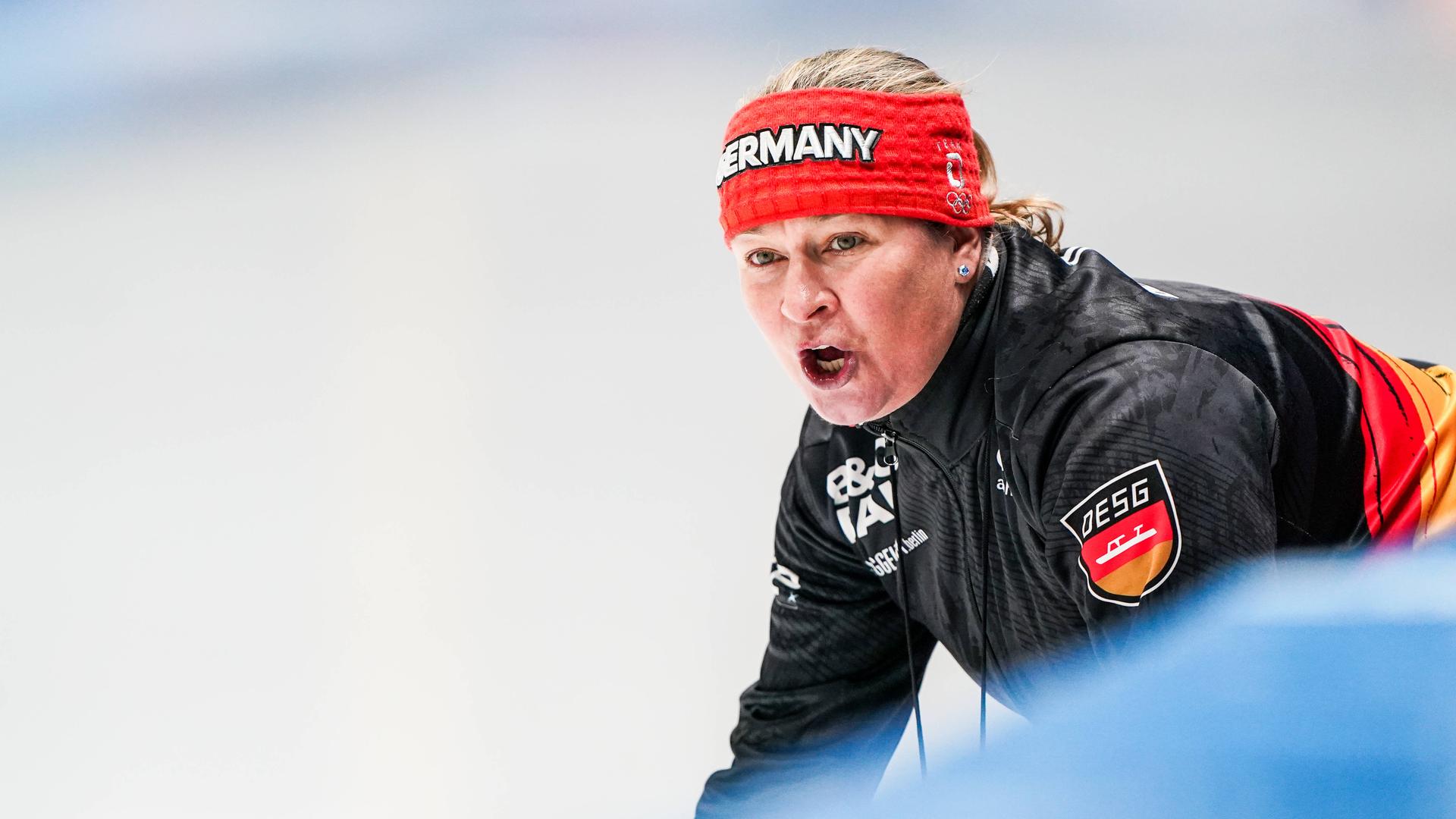 Claudia Pechstein als Trainerin am Rande der Strecke. Sie ruft etwas. 