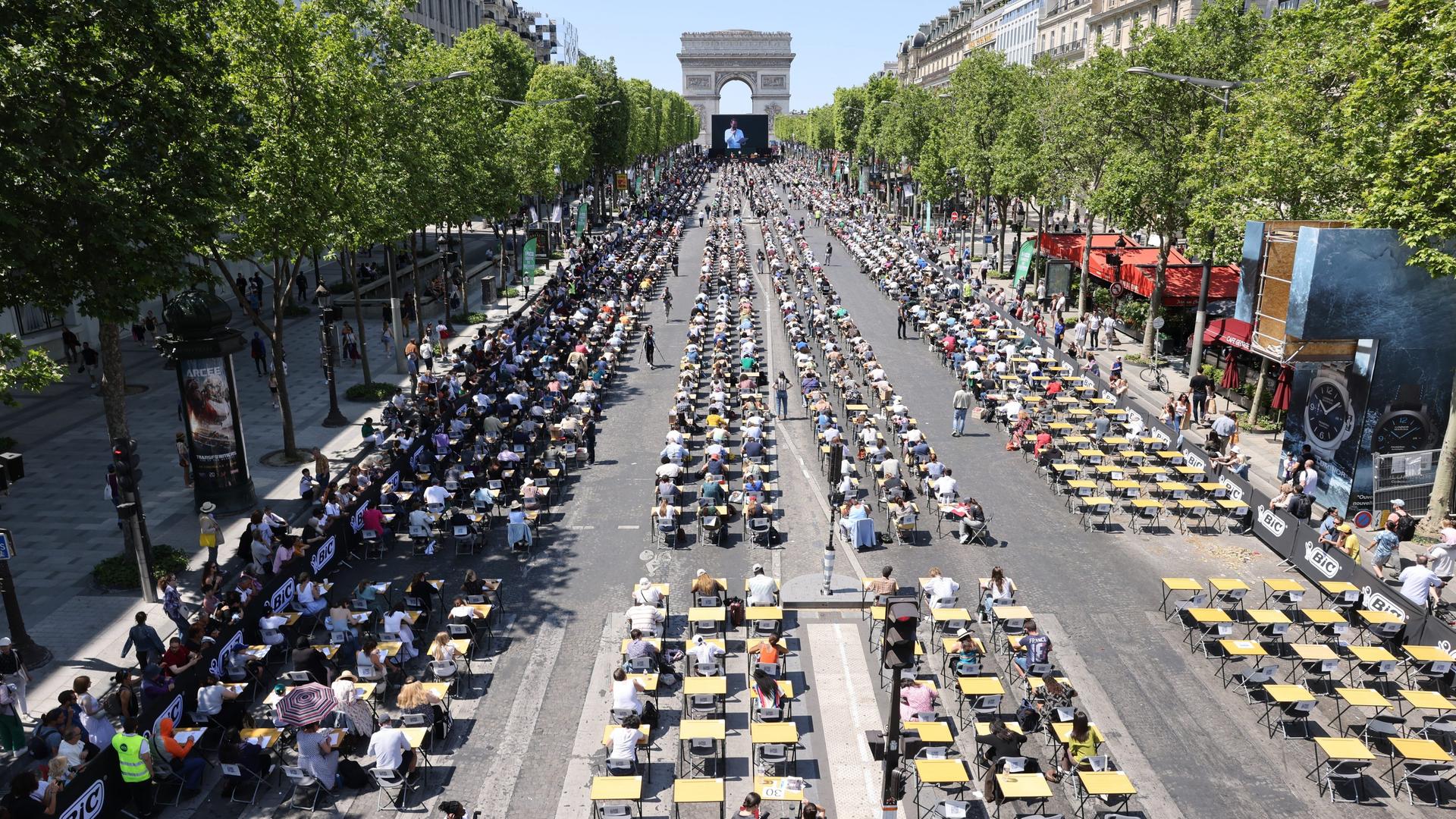 Schreibpulte für bis zu 1.700 Teilnehmende auf der Prachtstraße bis hin zum Triumphbogen in Paris.