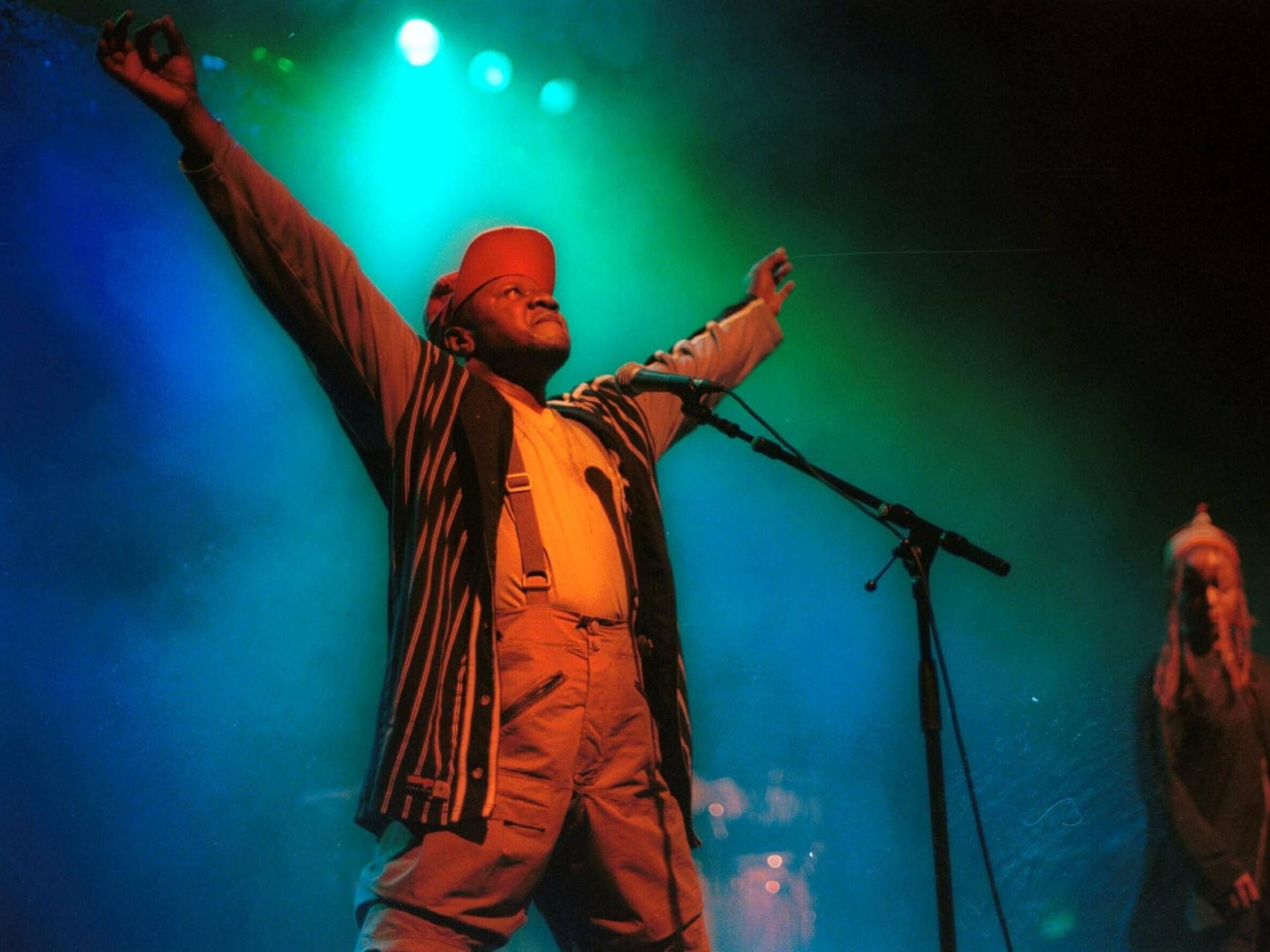 Papa Wemba steht mit ausgebreiteten Armen auf der Bühne