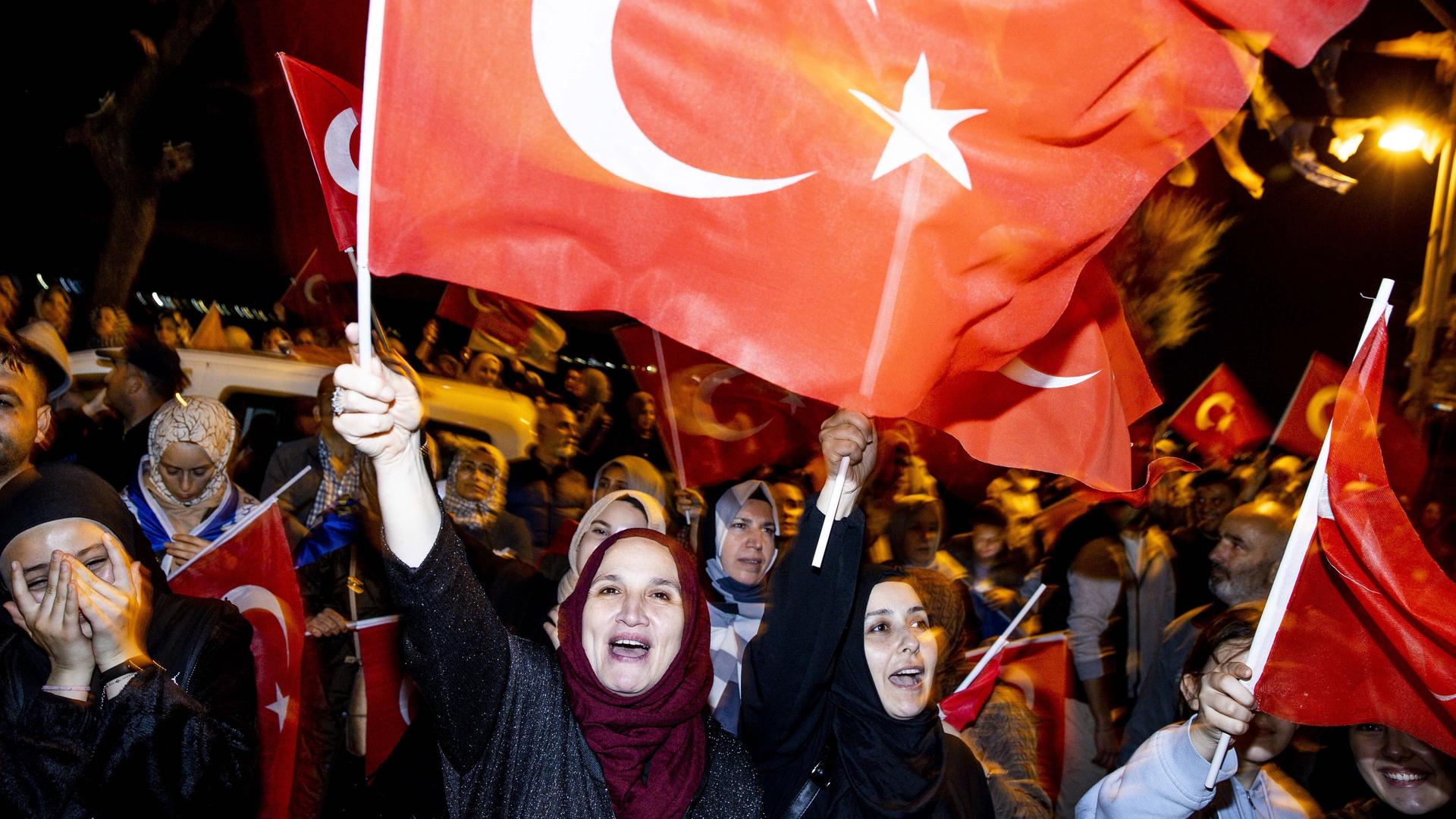 Erdogan-Anhänger feiern dessen Wahlsieg mit türkischen Fahnen.