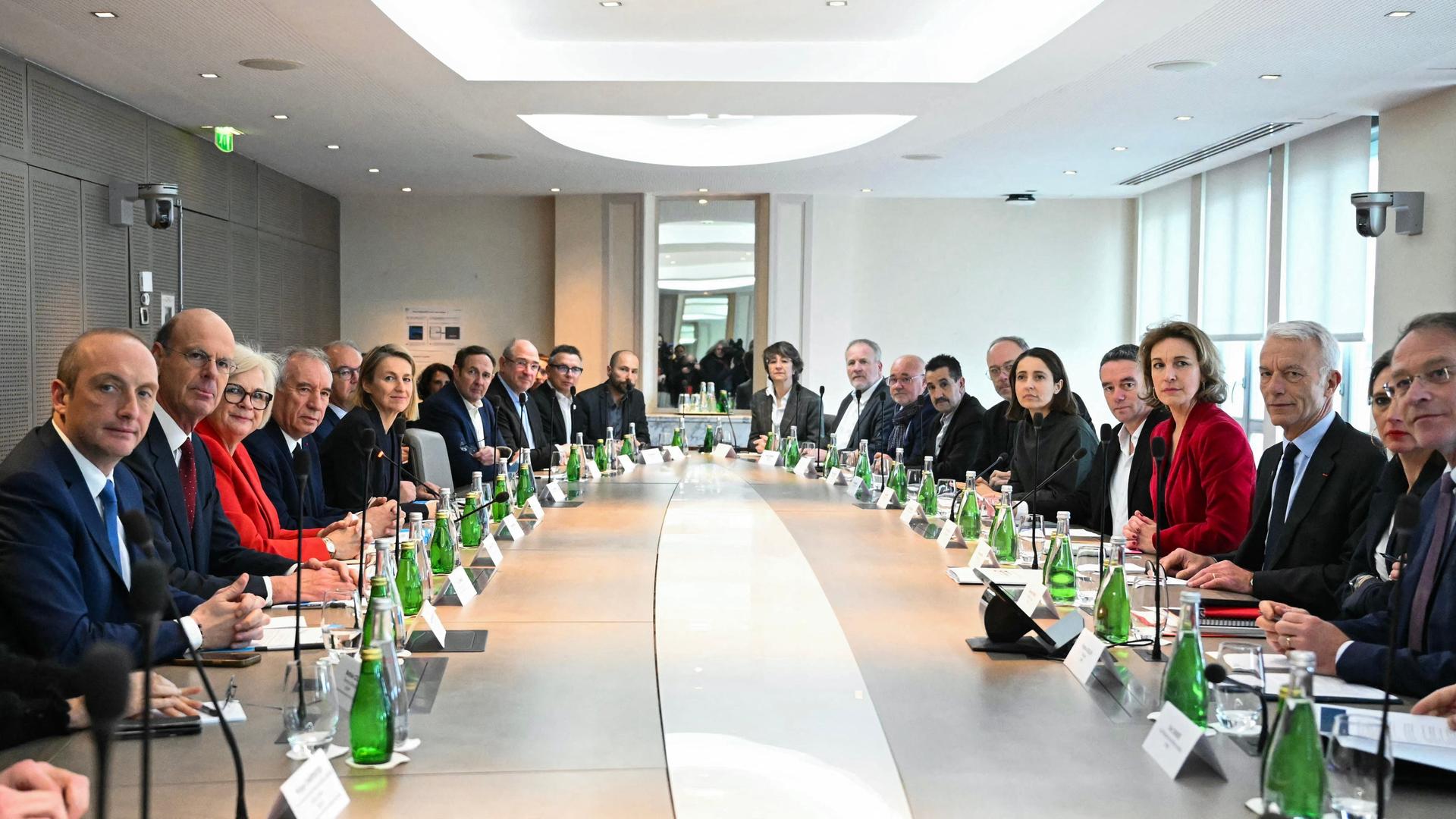 Der französische Premierminister Bayrou und viele Regierungsmitglieder sitzen an einem langen ovalen Tisch.