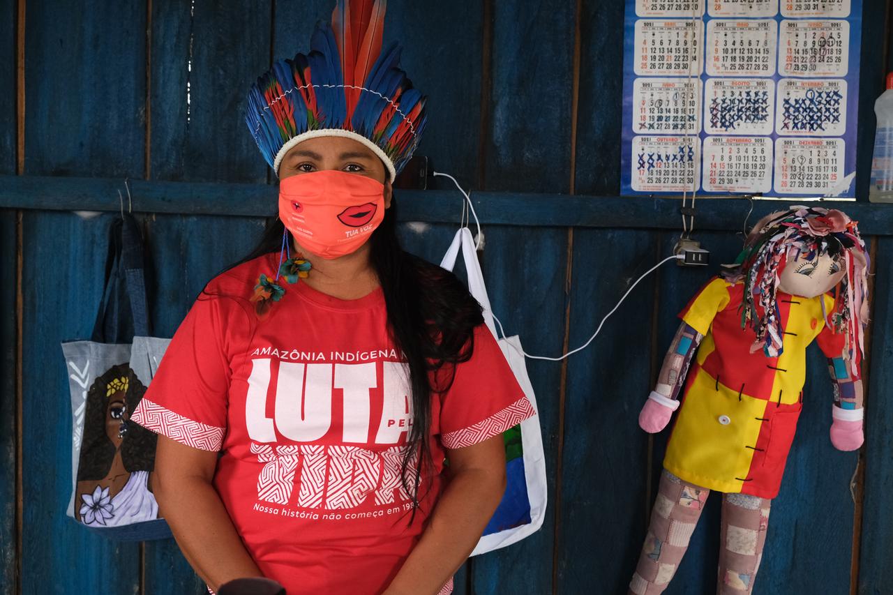 Eine junge Frau mit indigenem Kopfschmuck und in T-Shirt