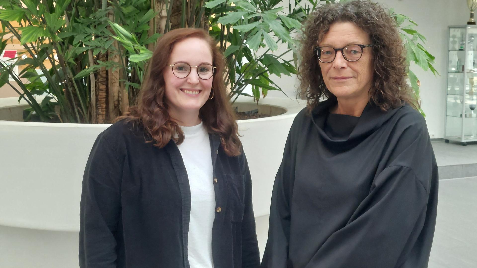 Jana Strotmann, die Leiterin des Beratungsteams des Hilfetelefons und Petra Söchting, die Leiterin des Hilfetelefons stehen nebeneinander.