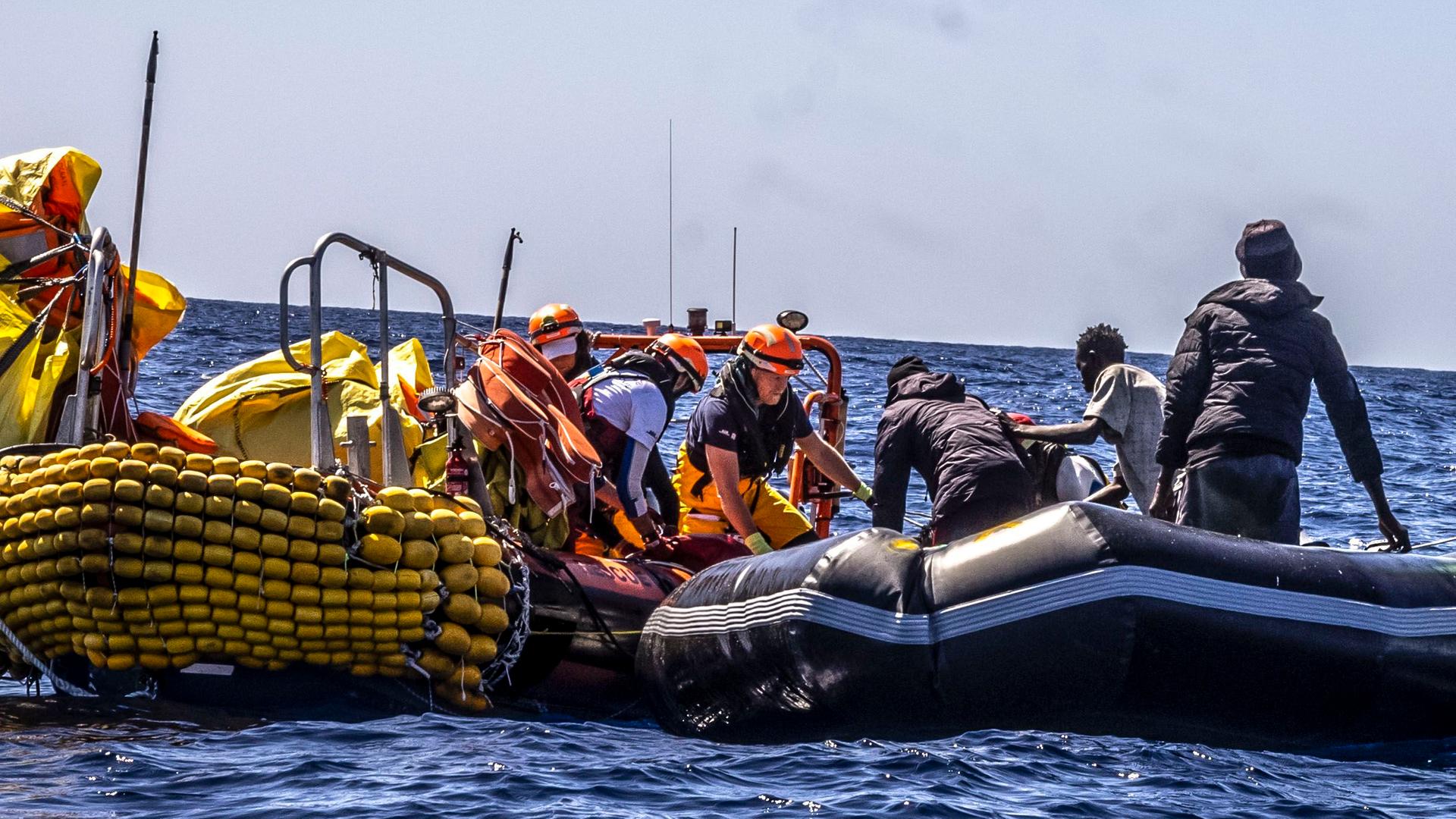 Migranten werden von Rettungskräften aus ihrem Schlauchboot geholt. 