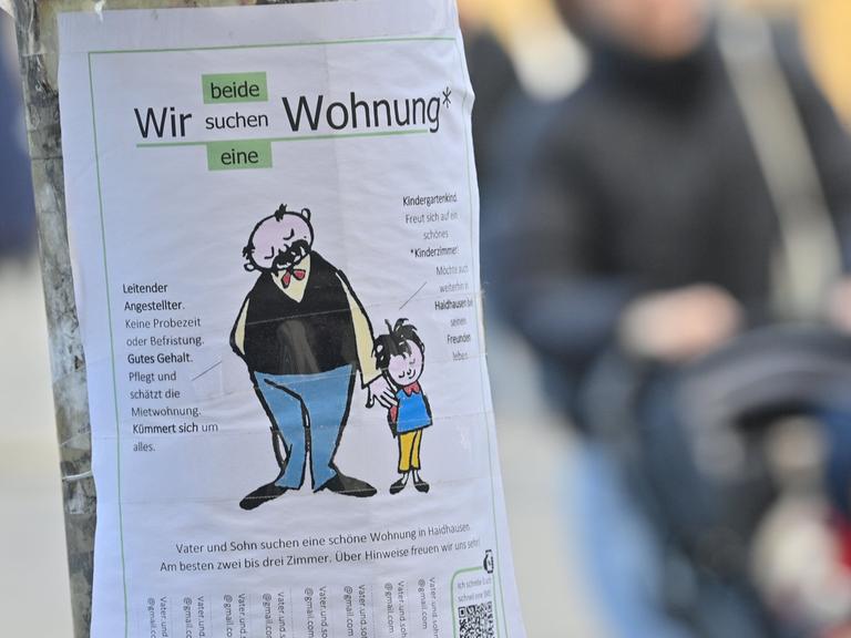 Mit einem Zettel mit der Aufschrift "Wir beide suchen eine Wohnung" an einem Laternenpfahl im Stadtteil München-Haidhausen sucht ein Vater mit seinem Sohn eine Wohnung.