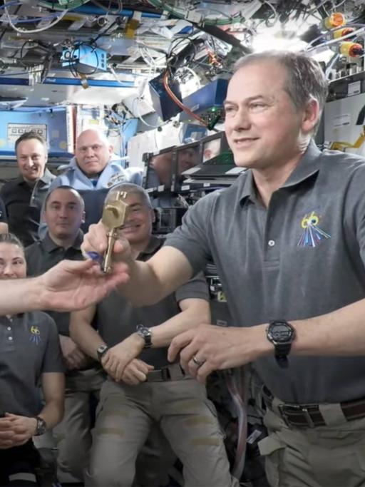 Der russische Kosmonaut Anton Schkaplerow übergibt symbolisch die ISS-Schlüssel an den US-amerikanischen Astronauten Thomas Marshburn.
