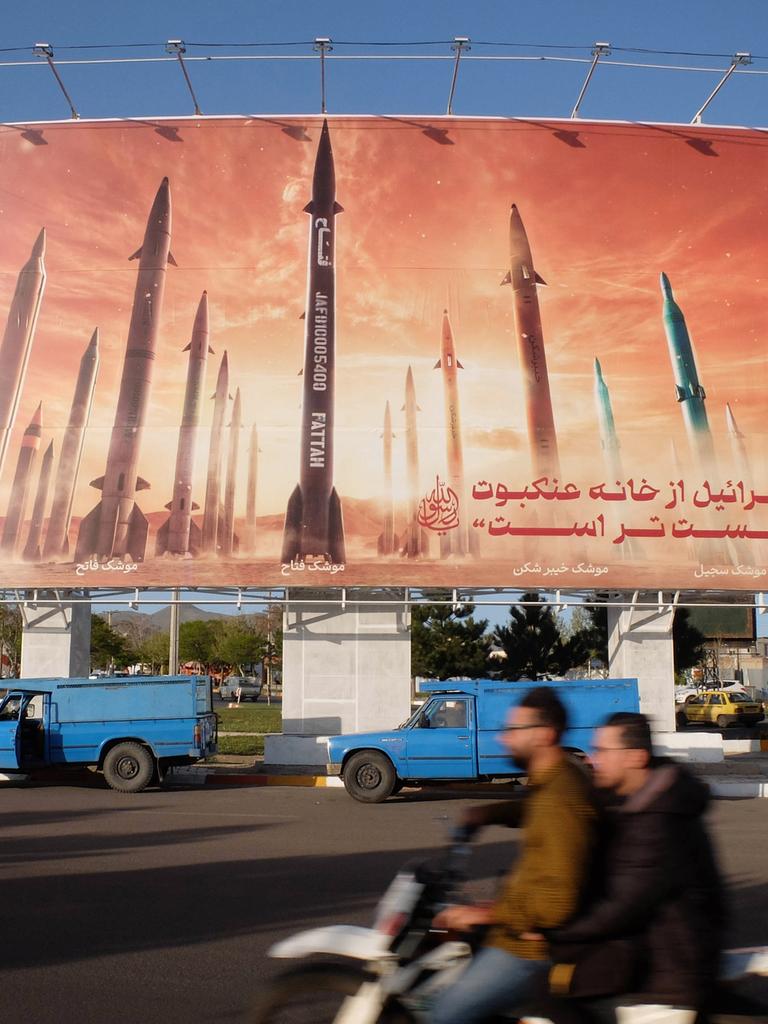 Autofahrer fahren an einer anti-israelischen Werbetafel vorbei, auf der Bilder iranischer Raketen und ein Satz auf Persisch zu lesen sind: "Israel ist schwächer als die Spinne zu Hause in Zanjan, Iran." Iran, 25. April 2024.