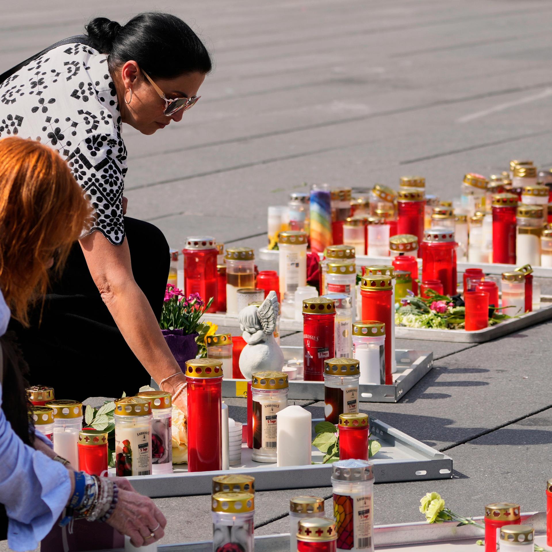 Menschen zünden auf dem Hauptplatz in Graz Kerzen an, nachdem ein ehemaliger Schüler am Vortag in einer Schule mehrere Menschen tötete und viele weitere verletzte, bevor er sich das Leben nahm.