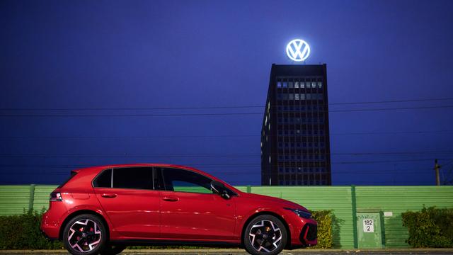 Ein roter VW Golf steht auf einem Parkplatz vor dem VW-Werk.