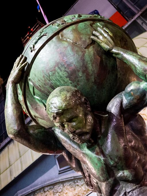 Eine Atlas-Skulptur wird am Hamburger Hauptbahnhof mit einem Kran auf das Dach gehoben.