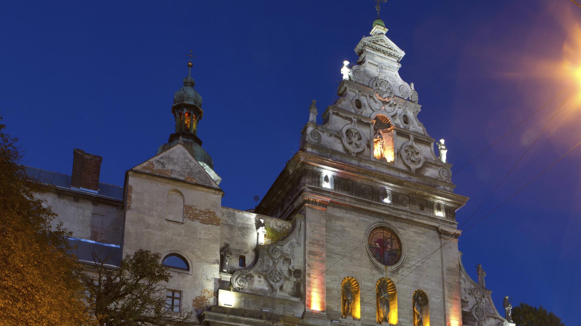 Kirche des Heiligen Andreas und des Gekreuzigten des Bernhardinerklosters in Lwiw im Licht der Laternen in der Nacht.