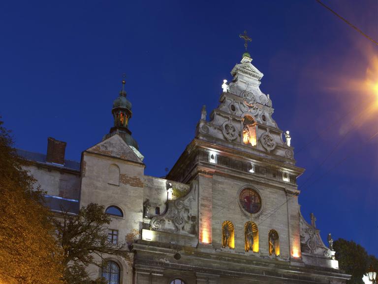 Kirche des Heiligen Andreas und des Gekreuzigten des Bernhardinerklosters in Lwiw im Licht der Laternen in der Nacht.