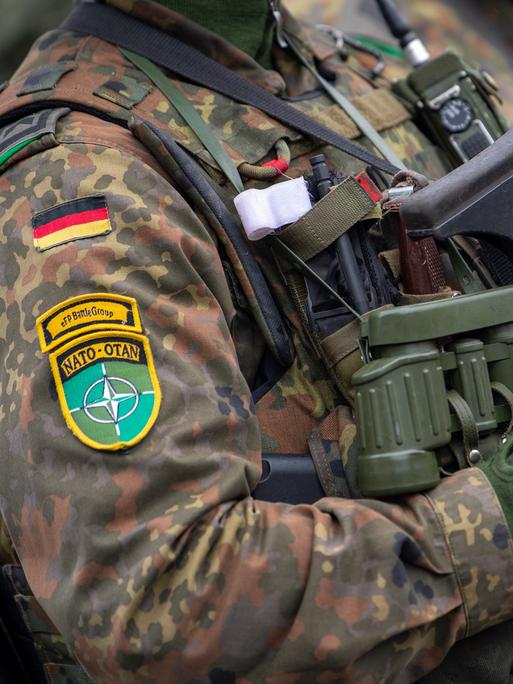 Soldaten der deutschen Bundeswehr und NATO Emblem an der Kleidung, in voller Ausrüstung.