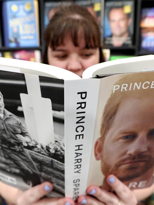 Eine junge Frau liest im Buch "Reserve" von Prinz Harry in einer Buchhandlung in Australien.