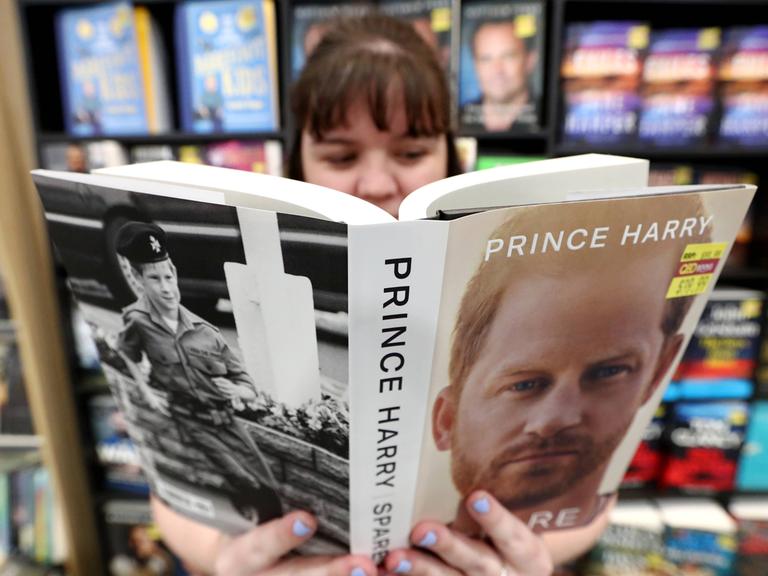 Eine junge Frau liest im Buch "Reserve" von Prinz Harry in einer Buchhandlung in Australien.