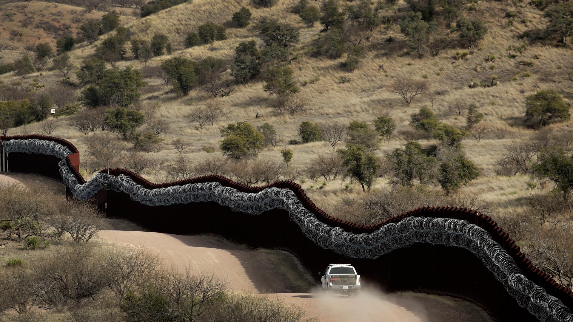 Eine Fahrzeug der Grenzsicherung fährt entlang der Mauer in Arizona